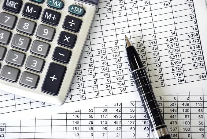 Calculator, pen and a printed accounts ledger
