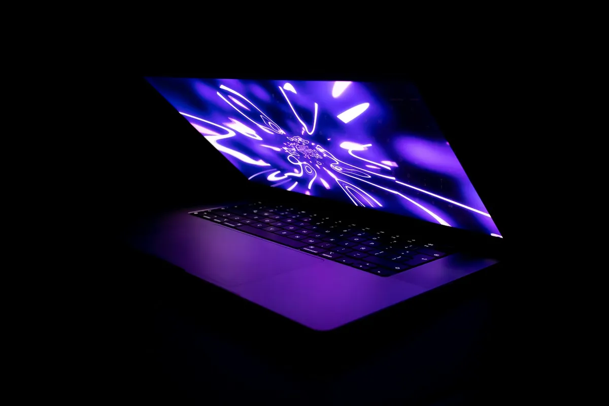 Open laptop with a glowing screen in a dark room