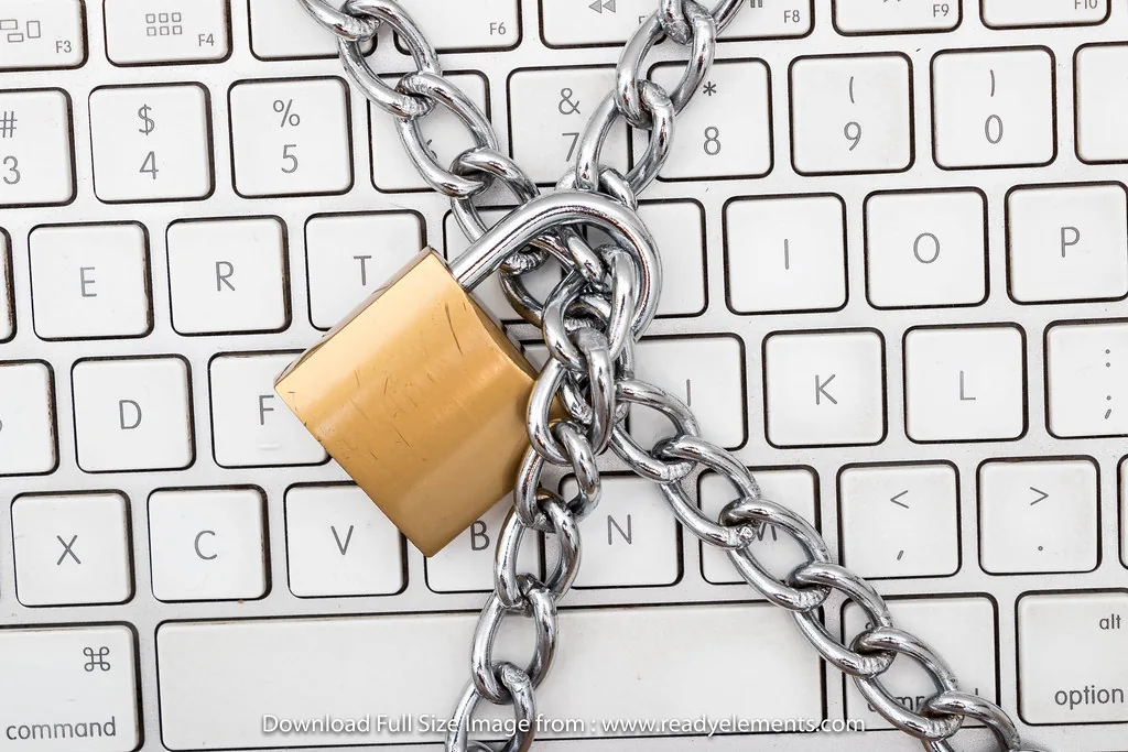 A padlock and chain lying across a computer keyboard